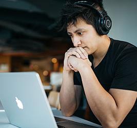 UB student on a laptop with headphones